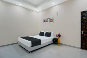 ein Schlafzimmer mit einem Bett in einem weißen Zimmer in der Unterkunft OYO Flagship The Elegance Resort in Dānāpur