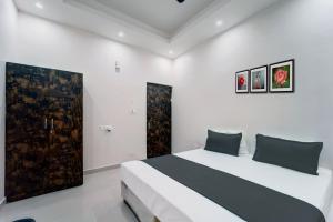 DānāpurにあるOYO Flagship The Elegance Resortのベッドルーム1室(ベッド1台付)が備わります。壁には絵画2点が飾られています。