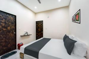 DānāpurにあるOYO Flagship The Elegance Resortのベッドルーム1室(ベッド1台、白黒の掛け布団付)