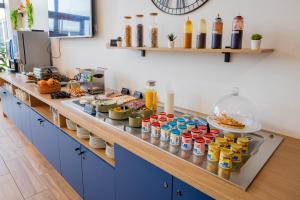 a buffet line with food and drinks in a kitchen at All Suites Appart Hôtel - Le Havre Centre - Les docks in Le Havre