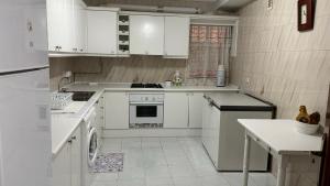 a white kitchen with white appliances and white cabinets at Apartamento Maldonado in Ronda