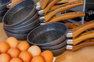 a bunch of pans and eggs on a table at All Suites Appart Hôtel - Le Havre Centre - Les docks in Le Havre