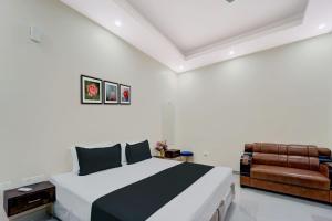 DānāpurにあるOYO Flagship The Elegance Resortの白いベッドルーム(ベッド1台、椅子付)