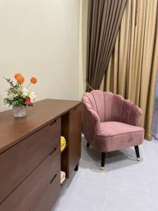 普吉市的住宿－Villa 3 bedrooms，一张粉红色的椅子坐在一个房间里梳妆台旁边