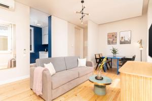 a living room with a couch and a table at Limehome Lisbon Rua do Arsenal in Lisbon