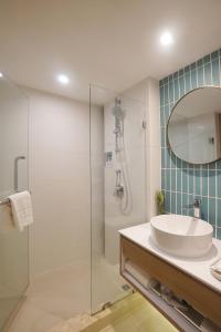 a bathroom with a sink and a shower with a mirror at SQ Boutique Hotel Managed by The Ascott Limited in Bangkok