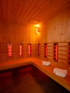 a sauna with red lights in a wooden room at All Suites Appart Hôtel - Le Havre Centre - Les docks in Le Havre