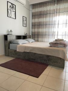 Un dormitorio con una cama grande con ventana. en Kate's Studio with view and free parking, en Serres