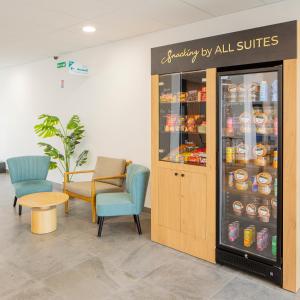 a waiting room with chairs and a refrigerator with drinks at All Suites Appart Hôtel - Le Havre Centre - Les docks in Le Havre