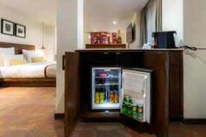 a small refrigerator in a room with a bed at Hotel Roadhouse in Kathmandu