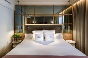 a bedroom with a large white bed with two pillows at Barceló Emperatriz in Madrid