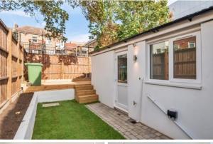 ein weißes Haus mit einer Tür und einem Hof in der Unterkunft 2Philipot in Eltham