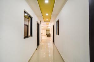 a hallway with white walls and a yellow ceiling at OYO Hotel Amber Palace in Bārmer