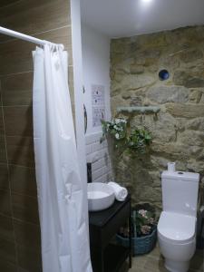 a bathroom with a white shower curtain and a toilet at Casita a estrenar en finca con rio y piscina próxima a Tui Gondomar y Portugal in Tui +92 photos