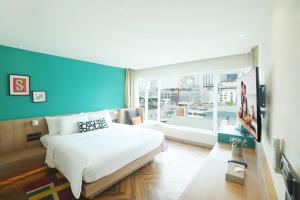 a bedroom with a large bed and a large window at SQ Boutique Hotel Managed by The Ascott Limited in Bangkok