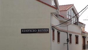 un panneau indiquant la rue sur le côté d'un bâtiment dans l'établissement Edificio Reyes, à La Adrada