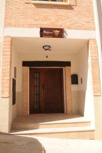 ラ・アドラダにあるEdificio Reyesの木製の扉付きの建物の入口