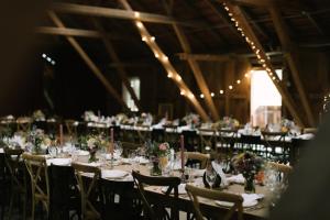 a banquet hall with tables and chairs with flowers at Gasthaus Fischerrosl in Münsing am Starnberger See