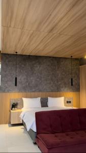 - une chambre avec un grand lit et un canapé dans l'établissement Lynn Resort Carita, à Sukarame