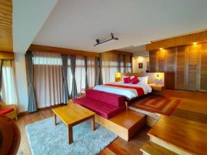een slaapkamer met een bed en een rode bank bij Eagle's Nest in Bhurtuk