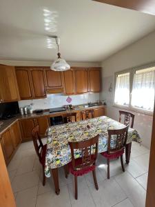 a kitchen with a table with chairs and a table cloth at The breath from The soul in Forza dʼAgro