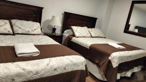 a hotel room with two beds and a mirror at Hotel 5° Estación in Caldera