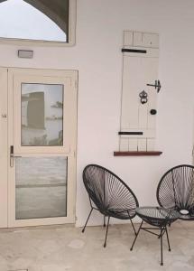 dwa krzesła i stół przed drzwiami w obiekcie Limassol Old Town Mansion w mieście Limassol