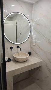 W łazience znajduje się umywalka i lustro. w obiekcie Limassol Old Town Mansion w mieście Limassol