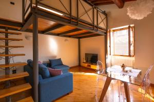 a living room with a blue couch and a loft bed at Loft Elegance in Pistoia