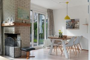a dining room with a table and a fireplace at Holiday home Haringvliet 11 - Noordzeepark Ouddorp, garden, terrace, carport, near the beach and dunes - not for companies in Ouddorp