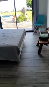 una camera con un letto e una sedia e una finestra di Villa Madè ad Alata