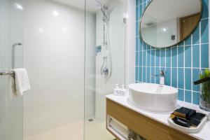 a bathroom with a sink and a shower at SQ Boutique Hotel Managed by The Ascott Limited in Bangkok