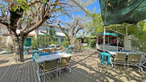 un patio al aire libre con mesas, sillas y árboles en Jasmin Pansiyon Çıralı, en Cıralı