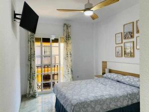 a bedroom with a bed and a ceiling fan at Playa Wabi Fuengirola in Fuengirola