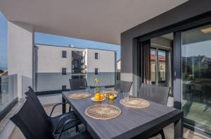 a dining table and chairs in a room with a balcony at Premium Apartments Mellea in Vantačići