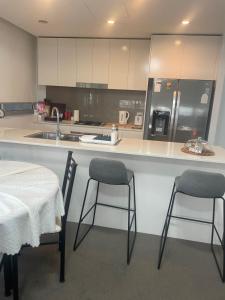 a kitchen with two chairs and a counter with a sink at Ocean view 2 Bedroom apartment in Sydney