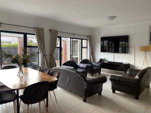 sala de estar con mesa y muebles de cuero negro en Remarkable 2-Bed Apartment in Harare en Harare