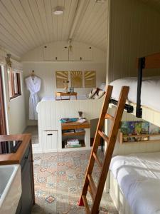 una stanza con due letti a castello e una scala di Ledmacoy Shepherds Huts a Strathdon
