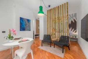 Una sala de estar con una mesa y sillas blancas. en Pretty Little Loft, en Rho