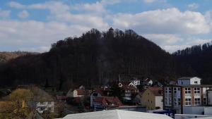 uma montanha com uma torre de relógio no topo de uma cidade em Rennsteighostel Thal em Ruhla