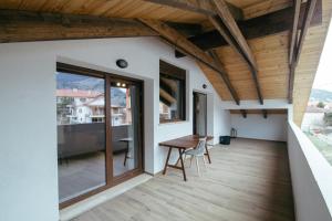 balkon z drewnianym stołem i drewnianym sufitem w obiekcie Ερυθρελάτη w Kalawricie