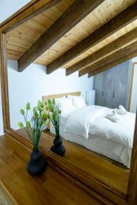 1 dormitorio con 1 cama y 2 jarrones sobre una mesa en Ερυθρελάτη en Kalavrita