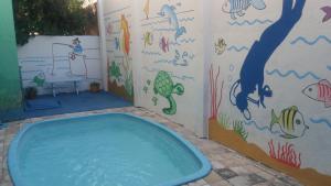 a bath tub in a bathroom with a painting on the wall at Pousada Suites das Galinhas in Porto De Galinhas