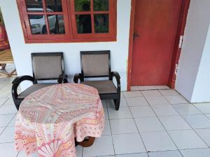mesa y sillas en una habitación con puerta roja en OYO 93841 Panorama Dewi, en Subang