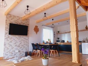 Il comprend une cuisine et un salon avec une table et des chaises. dans l'établissement Domek Z Widokiem Szaflary, à Szaflary