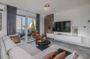 a living room with a couch and a tv at Premium Apartments Mellea in Vantačići