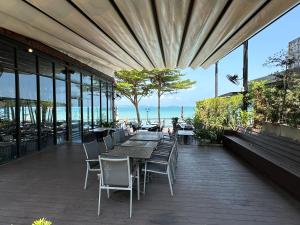 an outdoor patio with tables and chairs and the ocean at Majestic Residence 2Bedroom PoolVilla51, Beach Gate in Pattaya South