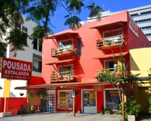 a red building on the corner of a street at Estalagem Maceió in Maceió