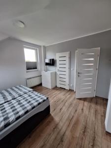 a bedroom with a bed and a wooden floor at Pokoje U IGORA in Mikołajki