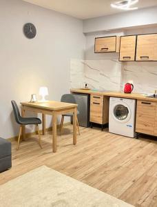 uma cozinha com uma mesa e uma máquina de lavar roupa em Atrakcyjne mieszkanie 14 em Lódź